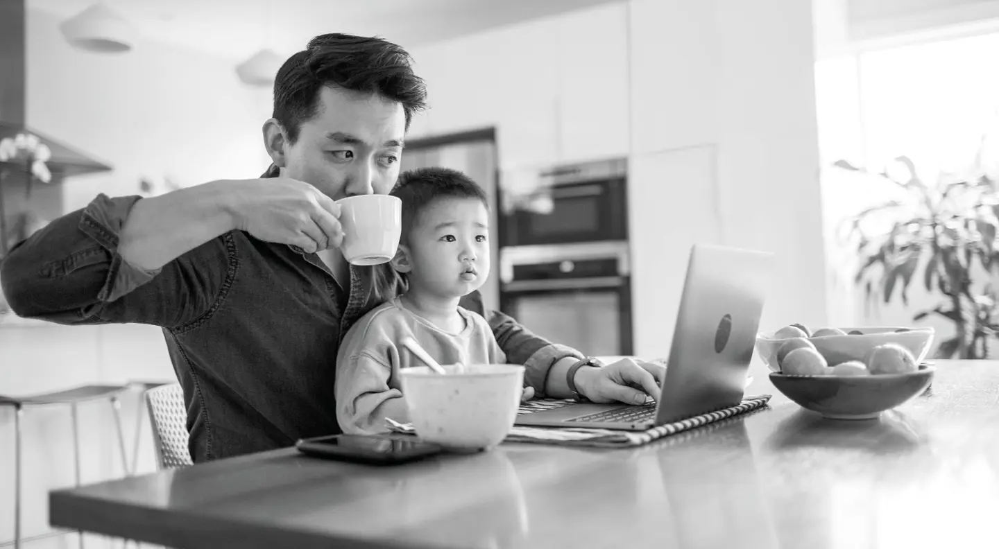 Dad on laptop with son on his lap
