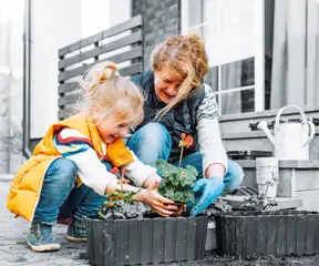 Child and grandmother planting flowers