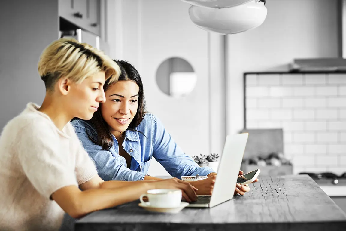 Two people looking at something on a laptop