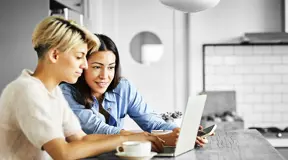Two people looking at something on a laptop