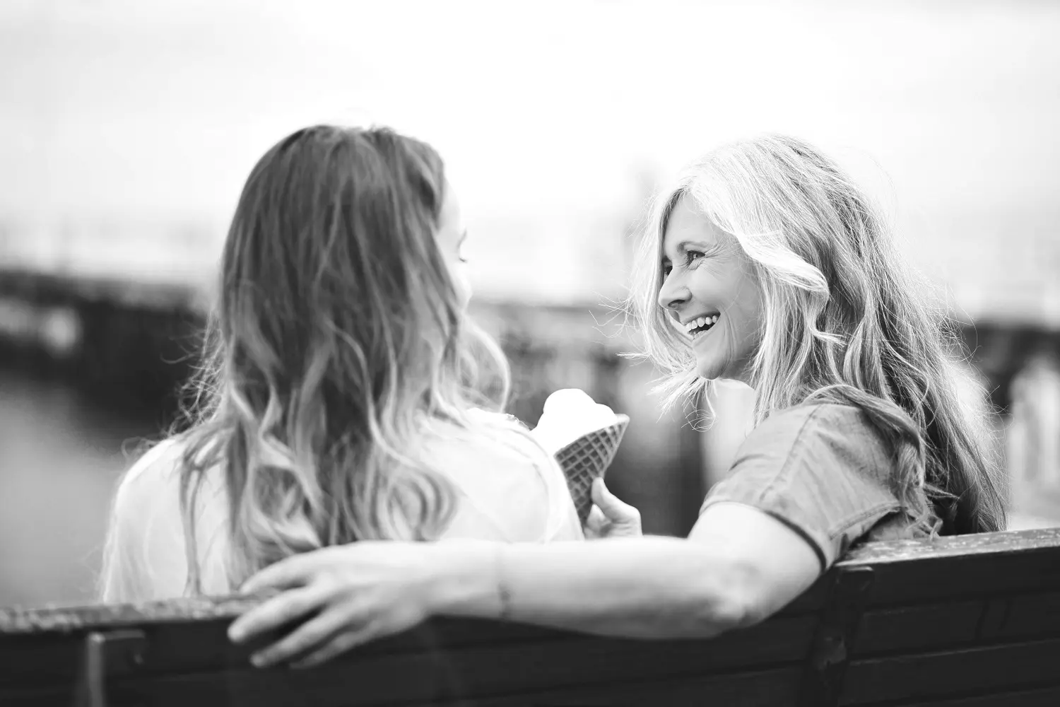 Friends sitting on bench having ice cream