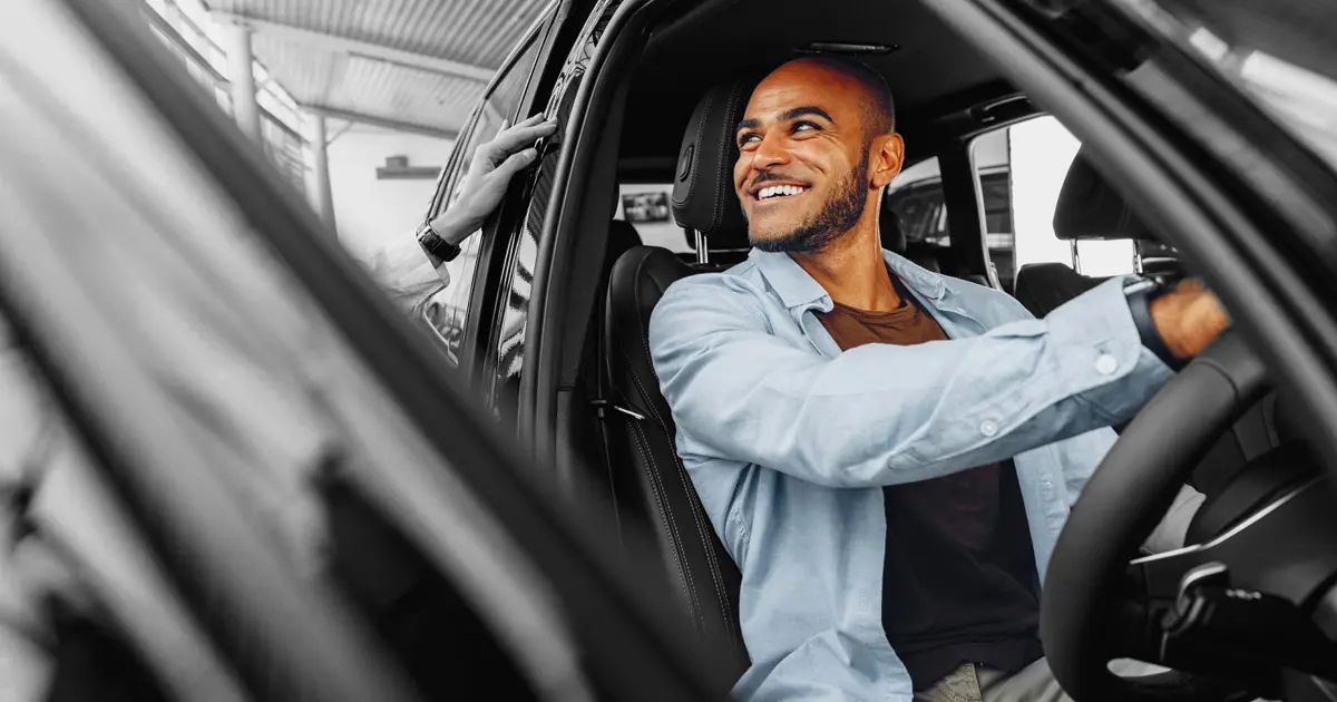 Person trying out a car in dealership