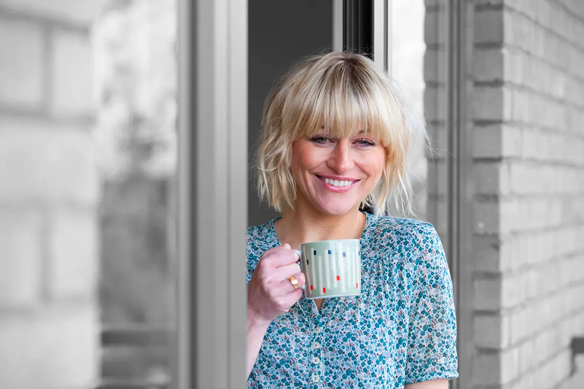 Smiling person drinking a cup of tea