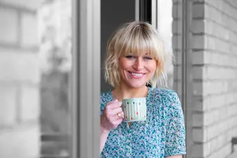 Smiling person drinking a cup of tea